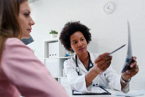 Doctor talking with patient at desk in medical office 