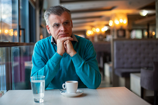 Man sitting in a restaurant with a cup of coffee