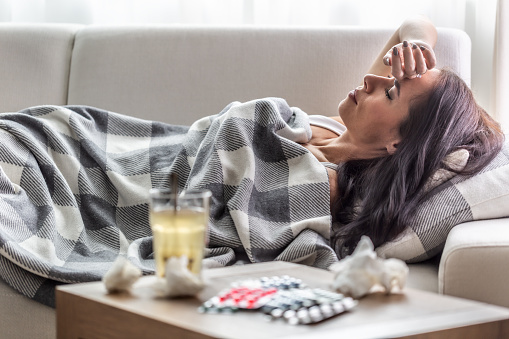Woman lying on couch feeling bad