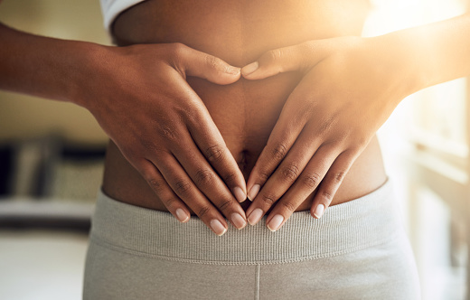 Cropped visual of a woman gently touching her stomach