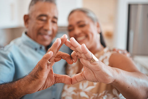 Mature couple making a heart with their hands