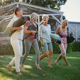Senior women walking with yoga mats